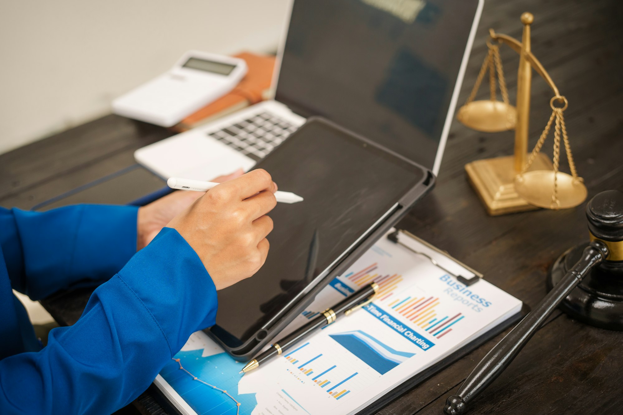 An Asian female lawyer sits her desk office,working on legal documents computer,providing online